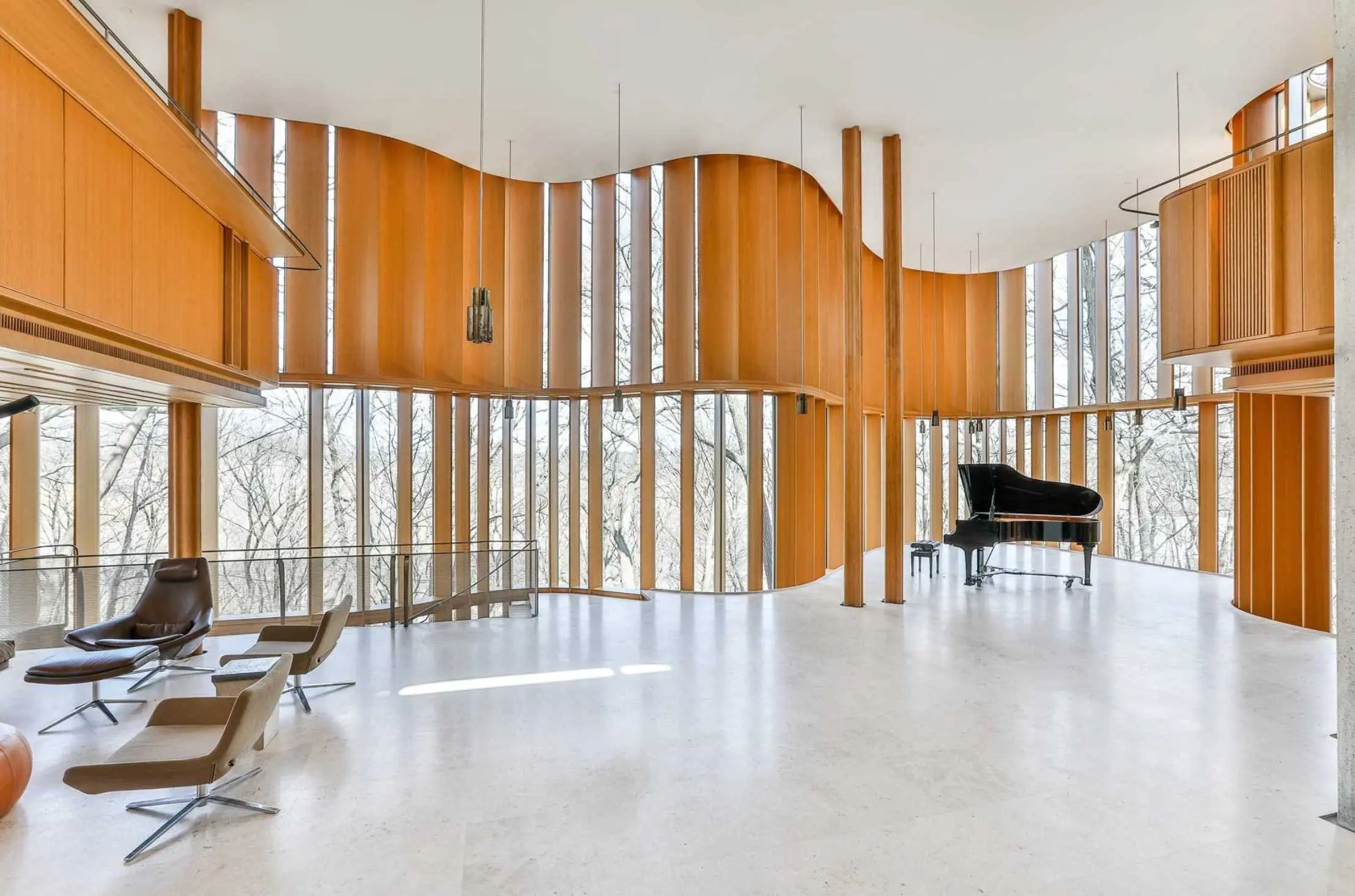 The two-storey concert hall inside Integral House, with a grand piano and curved oak slats