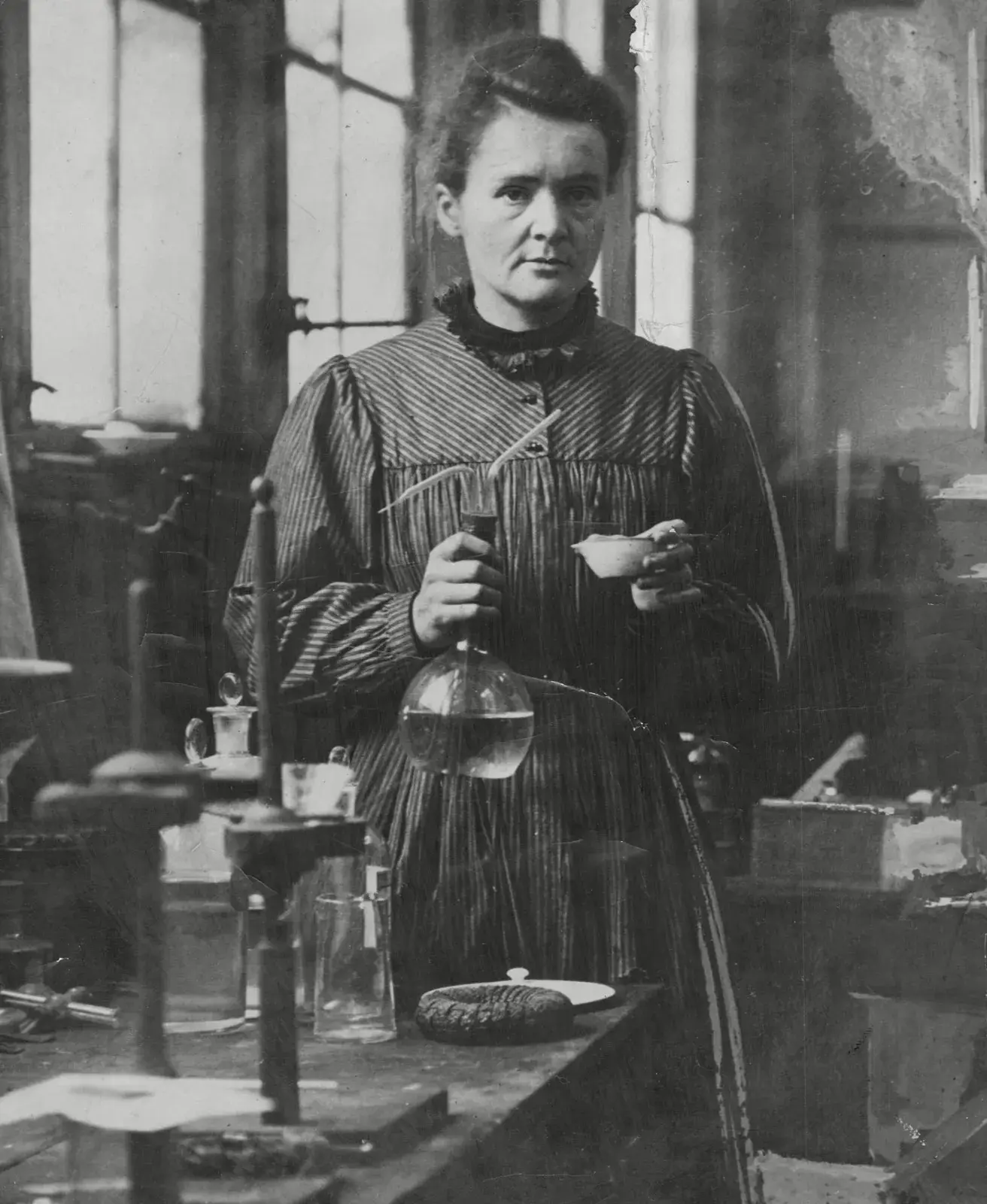 Marie Curie at work in her laboratory, surrounded by scientific equipment