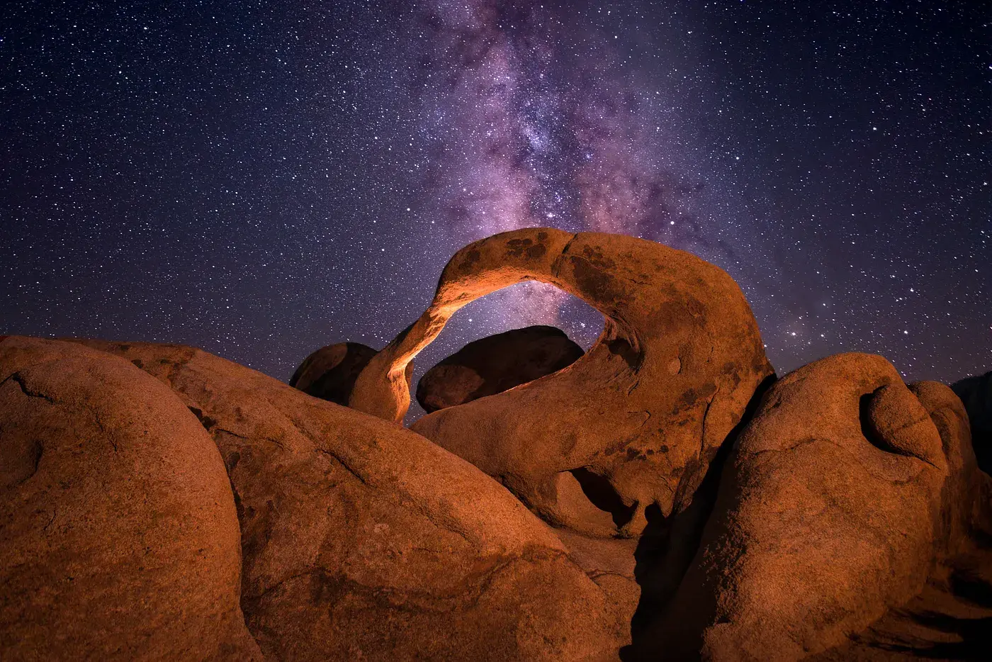 The natural Mobius Arch rock formation in Alabama Hills, California, under a starry night sky with the Milky Way galaxy visible