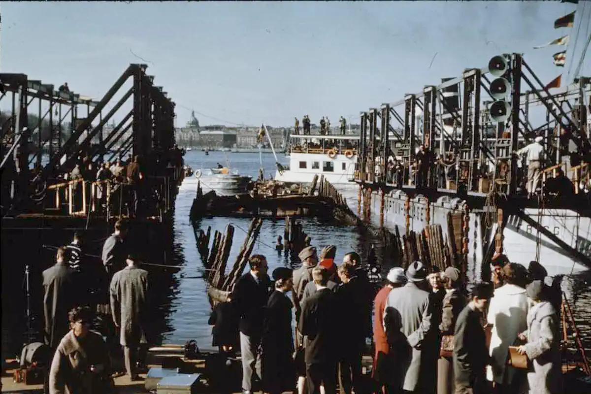 The Vasa's timbers emerge from the water between salvage pontoons as spectators watch
