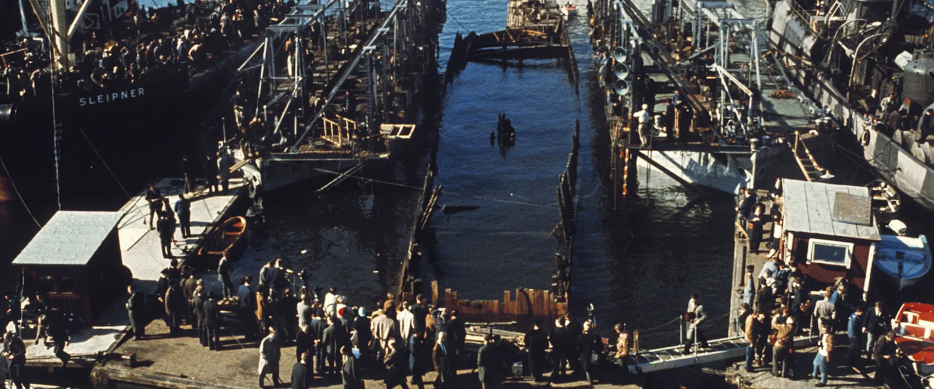 Crowds on the quays watch salvage pontoons lift the Vasa in Stockholm harbour, 1961